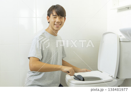 Asian young teen boy cleaning bathroom at home. Asian young teen boy cleaning bathroom at home. 138481977