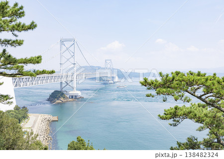 青空の下で鳴門海峡に架かる雄大な大鳴門橋と松の風景 138482324