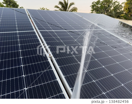 Water is sprayed on solar panels to clean them in a sunny location Water is sprayed on solar panels to clean them in a sunny location 138482456