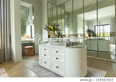 Luxury modern walk-in closet with mirror cabinets facades and island console. 138482563