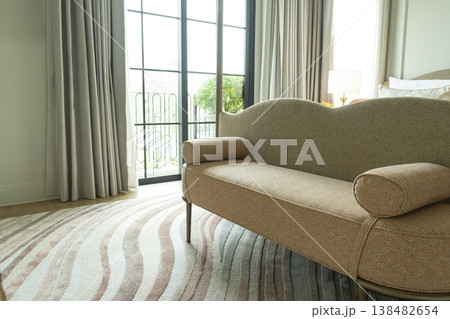 Detail of a bedroom with pastel freeform pattern rug and cozy bench. 138482654