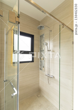 Glass walk-in shower with brown tiled surround 138482830