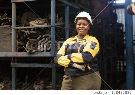 Technician African black women worker standing and smile in garage scrap yard old car part warehouse. Technician African black women worker standing and smile in garage scrap yard old car part warehouse. 138482889
