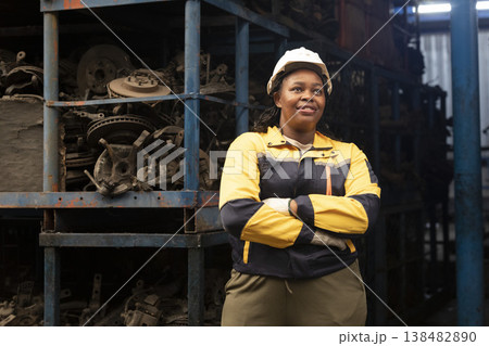 Technician African black women worker standing and smile in garage scrap yard old car part warehouse. 138482890