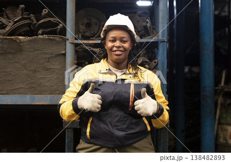 Technician African black women worker standing and smile in garage scrap yard old car part warehouse. 138482893