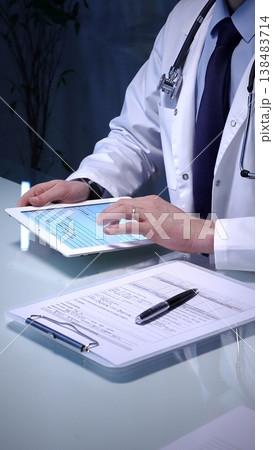 Medical doctor analyzing digital health records on a tablet computer, ensuring patient data management and secure care information in a modern clinic setting 138483714