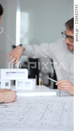 Architects and designer planning a modern house building project, collaborating on construction blueprints and architectural model in a professional office, close up Architects and designer planning a modern house building project, collaborating on construction blueprints and architectural model in a professional office, close up 138483745