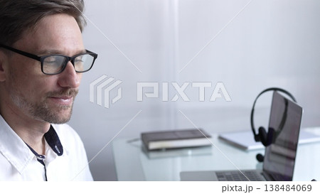 Businessman office worker attending online meeting using laptop and microphone, working remotely from home or office. Businesspeople concept Businessman office worker attending online meeting using laptop and microphone, working remotely from home or office. Businesspeople concept 138484069