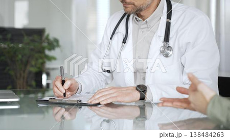 Doctor man writing prescription during patient consultation in clinic, providing medical advice and healthcare service. Medicine, health care and science concept 138484263