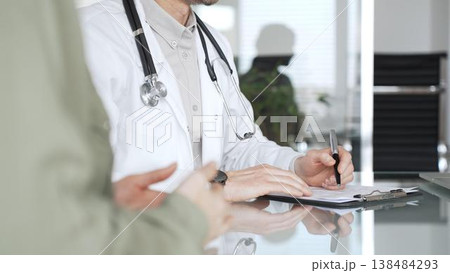 Doctor man writing prescription during patient consultation in clinic, providing medical advice and healthcare service. Medicine, health care and science concept Doctor man writing prescription during patient consultation in clinic, providing medical advice and healthcare service. Medicine, health care and science concept 138484293