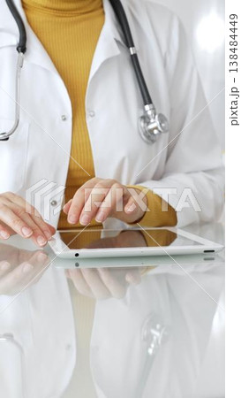 Doctor using tablet computer for digital health data, patient records, and medical application in clinic. Medicine, healthcare and science concept Doctor using tablet computer for digital health data, patient records, and medical application in clinic. Medicine, healthcare and science concept 138484449