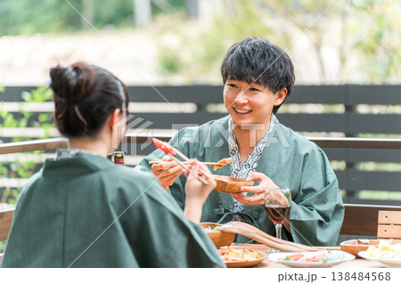 バルコニー・ウッドデッキで食事する旅館・温泉旅館に来た若いアジア人カップル（旅行・トラベル） 138484568