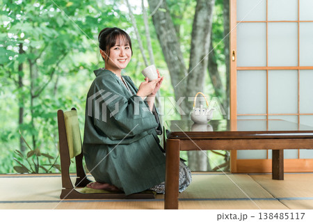 旅館の和室でお茶を飲む浴衣姿の若いアジア人女性 旅館の和室でお茶を飲む浴衣姿の若いアジア人女性 138485117