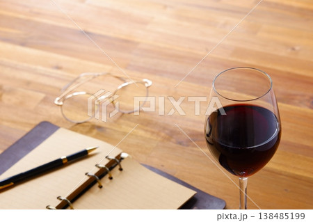 赤ワインを飲みながら、リング式のシステム手帳に日記をつけているイメージ写真 138485199