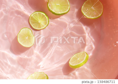 Fresh green lime slices floating in clear water with ripples texture. 138486711
