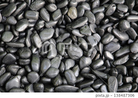 Smooth black river stones with a shiny wet surface. 138487306