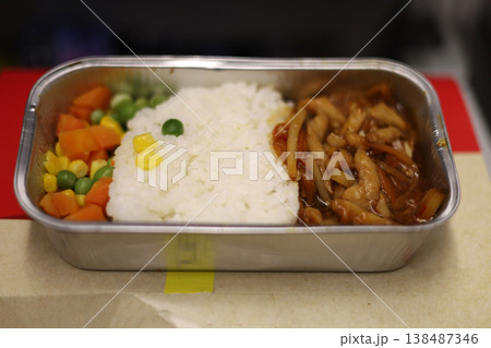 Airline meal with rice chicken sauce and mixed vegetables 138487346