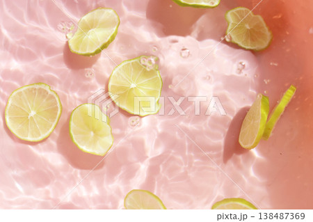 Fresh green lime slices floating in clear water with ripples texture. Fresh green lime slices floating in clear water with ripples texture. 138487369
