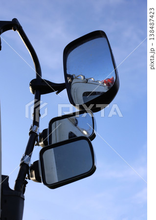 Triple side-view mirrors of a truck reflecting the clear sky. Triple side-view mirrors of a truck reflecting the clear sky. 138487423