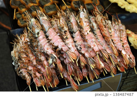 Prawns on skewers at a bustling Japanese fish market. Prawns on skewers at a bustling Japanese fish market. 138487487
