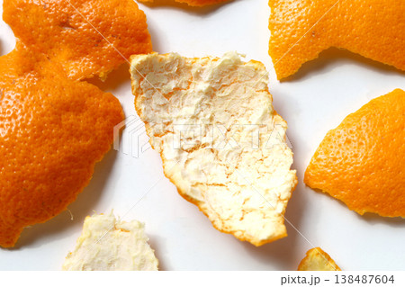 Fresh orange peels on a white surface. Fresh orange peels on a white surface. 138487604
