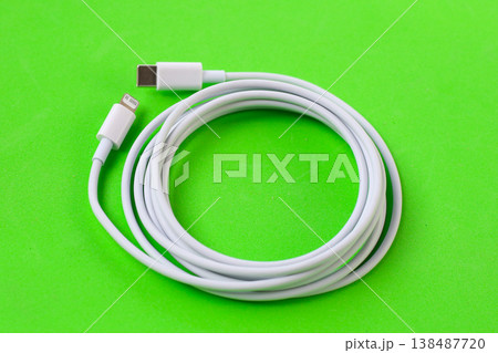 Cable with Type-C connector insulated, charging cable coiled on a green background. 138487720