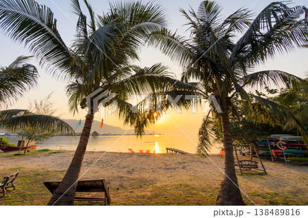 Colorful beach chairs on a peaceful sandy beach with palm trees and ocean view. Summer vacation in Thailand. 138489816