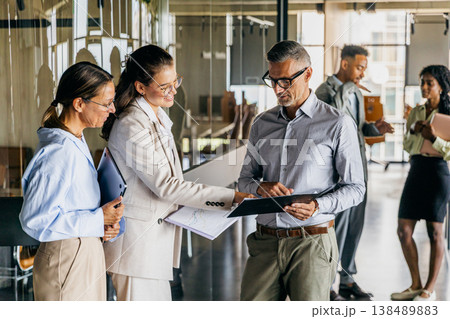 Chief financial officer meets team reviewing fiscal reports collaboratively Chief financial officer meets team reviewing fiscal reports collaboratively 138489883