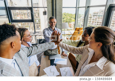 Colleagues of different ethnicities share joyful highfive moments 138489884