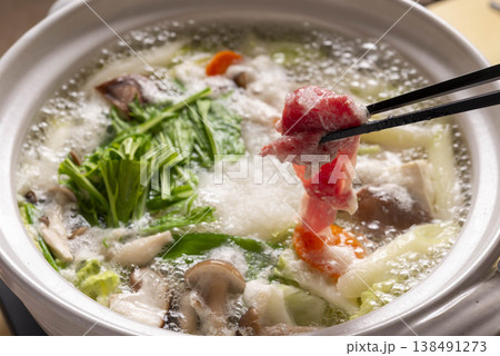 大根おろしたっぷりの鍋でラム肉をしゃぶしゃぶするシーン 箸でつまむ臨場感 水菜・きのこ入り冬の鍋料理 大根おろしたっぷりの鍋でラム肉をしゃぶしゃぶするシーン 箸でつまむ臨場感 水菜・きのこ入り冬の鍋料理 138491273