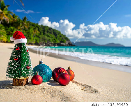 Miniature Christmas tree with santa hat and colorful ornaments on tropical beach sand with turquoise ocean and palm trees for holiday vacation and exotic celebration concepts 138491480