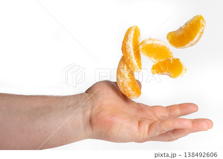 Sliced Orange Wedges Flying into Hand Sliced Orange Wedges Flying into Hand 138492606