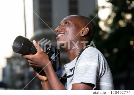 close-up of man with camera, smiling. close-up of man with camera, smiling. 138492774