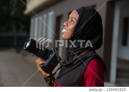 close-up of young muslim woman with camera, smiling. 138492829