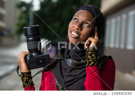 close-up of young muslim woman with camera, smiling. close-up of young muslim woman with camera, smiling. 138492830