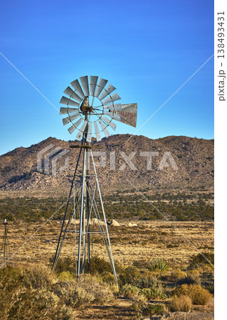 Windmill and Rugged Hills in Mojave Desert with Blue Sky Windmill and Rugged Hills in Mojave Desert with Blue Sky 138493431