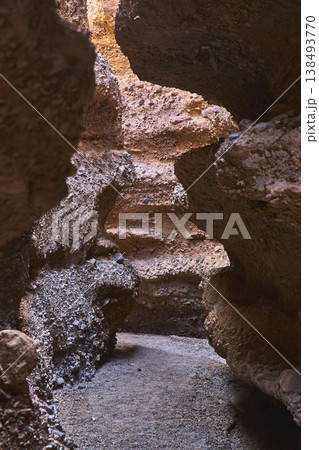 Slot Canyon Pathway With Textured Rock Walls And Sunlit Passage 138493770