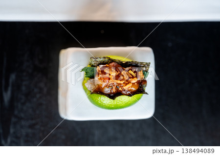 Luxurious fish amuse bouche resting on lime and ceramic with glossy reflections and crunchy topping Luxurious fish amuse bouche resting on lime and ceramic with glossy reflections and crunchy topping 138494089