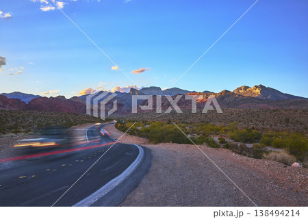 Red Rock Canyon Scenic Road with Blurred Cars and Dramatic Desert Mountains Nevada 138494214