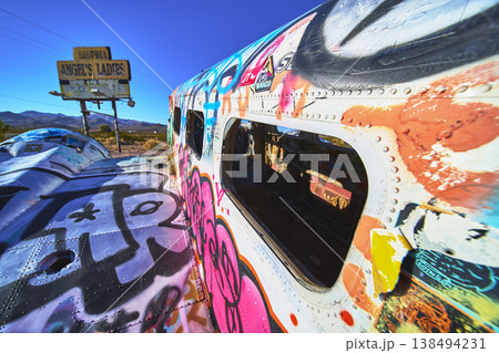 Graffiti Covered Abandoned Airplane and Angels Ladies Sign in Beatty Nevada Desert 138494231
