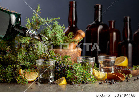 Gin is poured from a vintage bottle into a glass. 138494469