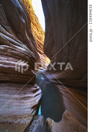 Slot Canyon Water Pools and Sunlit Rock Formations in Dramatic Narrow Passage Slot Canyon Water Pools and Sunlit Rock Formations in Dramatic Narrow Passage 138494638
