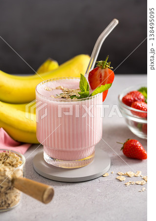 Pink strawberry, banana, oats smoothie in a glass with fresh fruits, dark background Pink strawberry, banana, oats smoothie in a glass with fresh fruits, dark background 138495095