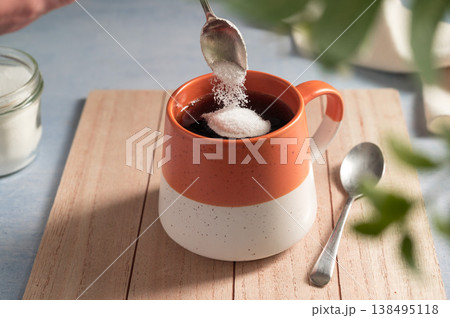 Pouring sweetener powder in cup of coffee. Sugar alternative, food and nutrition Pouring sweetener powder in cup of coffee. Sugar alternative, food and nutrition 138495118