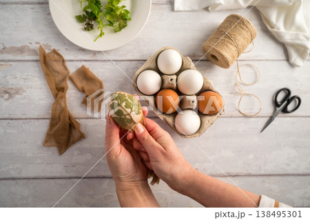 DIY Easter eggs with natural leaves, creating patterns on eggs using plants. Eco friendly colouring easter eggs 138495301