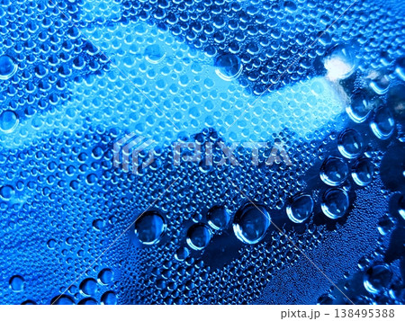 Close-up of numerous blue water drops on a surface, creating a refreshing and cool abstract background texture. Perfect for themes of purity, hydration, and liquid dynamics. 138495388