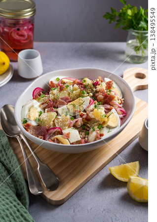 Egg potato salad with bacon and fresh herbs in a plate 138495549