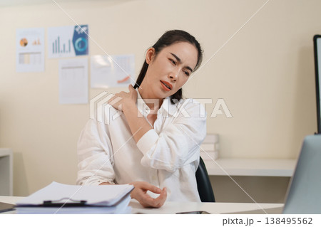 Office worker experiencing neck and back pain from prolonged computer work Office worker experiencing neck and back pain from prolonged computer work 138495562