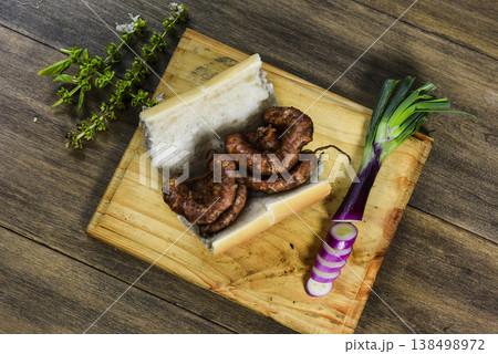 Cow bowels presented on a wooden board with ingredients, ready to grill Cow bowels presented on a wooden board with ingredients, ready to grill 138498972