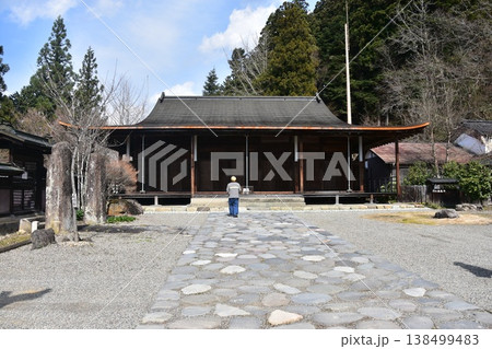 日本の岐阜県の高山市 国指定重要文化財の照蓮寺 日本建築の美しい本堂と石畳の参道 参拝する男性の後姿 日本の岐阜県の高山市 国指定重要文化財の照蓮寺 日本建築の美しい本堂と石畳の参道 参拝する男性の後姿 138499483